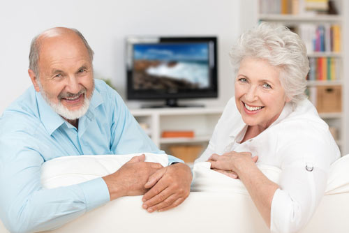 Older couple relaxing comfortably in their air-conditioned living room